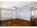 Bright living room featuring hardwood floors, a ceiling fan, and large windows with plantation shutters at 509 Mcintosh Rd, Ormond Beach, FL 32174