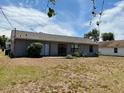 Backyard view featuring a home with a gray exterior and sliding glass doors at 662 Comstock Dr, Deltona, FL 32738