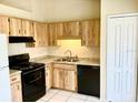 Kitchen features light wood cabinets, granite countertops, and black appliances at 662 Comstock Dr, Deltona, FL 32738
