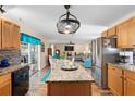 Bright kitchen featuring granite countertops, stainless steel appliances, and a view into the adjacent living room at 707 Leeward Dr, Deltona, FL 32738