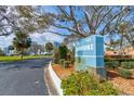 Community sign for Bayshore with mature trees, manicured landscaping, and a view of the condo building at 925 N Halifax Ave # 910, Daytona Beach, FL 32118