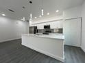 Modern kitchen featuring sleek white cabinetry, stainless steel appliances, an island with a sink, and pendant lighting at 951 Redwood St, Daytona Beach, FL 32117