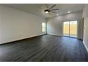 Spacious living room featuring modern ceiling fan, gray flooring, with sliding glass door that provides ample natural light at 951 Redwood St, Daytona Beach, FL 32117