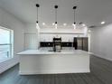 Stylish kitchen with white cabinetry, quartz countertops, stainless steel appliances, and decorative pendant lights at 955 Redwood St, Daytona Beach, FL 32117
