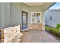 Inviting front porch with stone accents, tiled floor, and a stylish entryway at 1079 Lincolnshire Dr, Deland, FL 32724