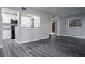 Open floorplan showcasing modern living room with gray floors flowing into the updated kitchen at 100 Sweetgum Woods Ct # 10C, Deltona, FL 32725