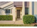 Inviting front entryway framed by manicured bushes and featuring a modern door and neutral tones at 101 Grand Plaza Dr # M1, Orange City, FL 32763
