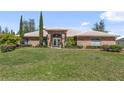 Sprawling home with a lush lawn, manicured landscaping, and a brick facade under a blue sky at 1058 W Seagate Dr, Deltona, FL 32725