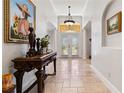 Grand foyer featuring soaring ceilings, travertine floors and a decorative console table at 1058 W Seagate Dr, Deltona, FL 32725
