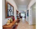 Hallway with decorative table and mirror and a view to the open-concept living room in the background at 107 Gladesdown Ct, Deland, FL 32724