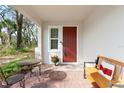 Cozy front porch featuring outdoor seating and a decorative red door at 1088 Happy Forest Loop, Deland, FL 32720