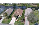 Aerial view of a home near a pond featuring well-maintained landscaping and a private driveway at 111 Brown Crane Ct, Daytona Beach, FL 32119