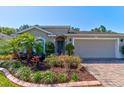 Charming single-story home with brick driveway and meticulously landscaped front yard at 1423 Chelsea Manor Cir, Deland, FL 32724