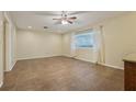 Expansive living room with tile flooring, ceiling fan, and two large windows at 1493 Derbyshire Rd, Daytona Beach, FL 32117