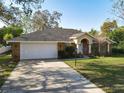 Attractive single-story home with brick facade, attached garage, and a long driveway at 151 Lucerne Dr, Debary, FL 32713