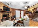 Warm living room showcasing a brick fireplace, wooden paneling, and carpeted stairs at 1572 Darlington Ave, Deltona, FL 32725