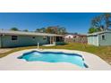 Enjoy this backyard pool with well-maintained lawn, screened in porch, and exterior building at 1609 Raleigh Ave, Daytona Beach, FL 32117