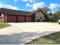 Spacious three-car garage featuring a basketball hoop and expansive driveway, great for entertainment at 1990 Spruce Creek N Cir, Port Orange, FL 32128