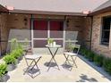 Cozy patio seating with chairs and a small table, surrounded by well-maintained landscaping and a red brick home at 1990 Spruce Creek N Cir, Port Orange, FL 32128
