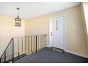 A front door and wrought iron railing are lit by a decorative chandelier in the entryway at 200 Saint Andrews Blvd # 2804, Winter Park, FL 32792