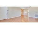 An empty living room features glossy wood floors, neutral walls, and natural light from the entry at 200 Saint Andrews Blvd # 2804, Winter Park, FL 32792