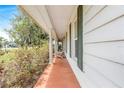 Covered porch with seating offering an inviting outdoor space with white pillars and green shutters at 28 W Highbanks Rd, Debary, FL 32713