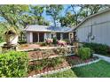 Beautifully landscaped front yard featuring colorful flowers, lush greenery, and a charming one-story home at 29 Ramblewood Trl, Deland, FL 32724
