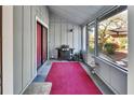 Cozy screened-in porch area with a grill, red rug, and view of the outdoor space at 29 Ramblewood Trl, Deland, FL 32724