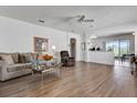 Spacious living room with hardwood floors, ceiling fan, and a view of the kitchen at 307 Heron Point Way, Deland, FL 32724