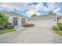 Exterior of a house featuring a garage, landscaped yard, and a walkway leading to the front door at 369 Caddie Dr, Debary, FL 32713
