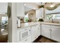 Bright kitchen with white cabinets and modern appliances open to an adjacent living space at 37 Fairway Ct # C, Deland, FL 32724