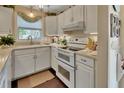 Well-lit kitchen with white cabinetry, modern appliances, and ample counter space at 37 Fairway Ct # C, Deland, FL 32724