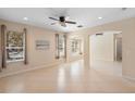 Spacious living room with tiled floors, open archways, recessed lights, and large windows providing ample natural light at 406 Ravenshill Way, Deland, FL 32724