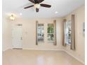 Bright living room with tiled floors, neutral walls, a ceiling fan, and natural light from multiple windows at 406 Ravenshill Way, Deland, FL 32724