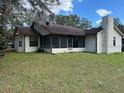Exterior of home with large backyard, including a screened-in porch and mature trees at 4164 New Marsh Rd, Deland, FL 32724