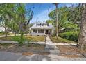 Charming gray two-story home with a metal roof, inviting front yard, and picturesque trees at 427 E Church St, Deland, FL 32724