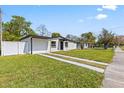 Charming exterior featuring a well-maintained lawn, driveway, and partial fence in a bright daytime setting at 4333 Arch St, Orlando, FL 32808