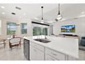 Open-concept kitchen with a breakfast bar, stainless steel appliances, and a view into the living area at 464 Tropics Ave, Daytona Beach, FL 32124
