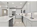 Spacious kitchen featuring white cabinetry, stainless steel appliances, and elegant marble flooring at 464 Tropics Ave, Daytona Beach, FL 32124