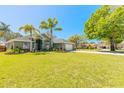 Lovely green home with a well-maintained lawn, palm trees, and an extra-long brick-paved driveway leading to a two-car garage at 6 Greenvale Dr, Ormond Beach, FL 32174
