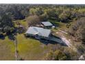 Beautiful aerial view of a brick home with metal roof, large lot, barn and storage shed at 600 Tabatha Dr, Osteen, FL 32764