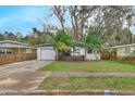 Charming single-story home with a well-manicured lawn, mature trees, and a quaint curb appeal at 761 Greenway Pl, Daytona Beach, FL 32114