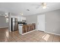 Bright kitchen features tiled floor, modern stainless appliances, breakfast bar, and ample cabinet space at 1020 Alladin Dr, Deltona, FL 32725
