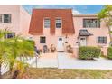 Lovely exterior view of townhomes with peach exterior, landscaping, and red roof at 108 Mitchell Pl # 108, Daytona Beach, FL 32118