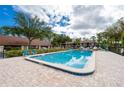 Community pool with brick patio, perfect for relaxation and enjoying the outdoors at 112 Lacosta Ln # 115, Daytona Beach, FL 32114