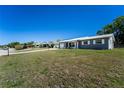 A single-story home sits on a verdant lot underneath a clear blue sky at 1199 Galgano Ave, Deltona, FL 32725
