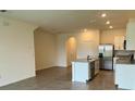 Open-concept kitchen with stainless steel appliances, granite counters, and an adjacent living area at 131 Reena Dr, Daytona Beach, FL 32117