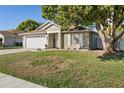 Inviting home with a neatly landscaped lawn, white garage door, and charming front porch at 1340 Babcock Ave, Deltona, FL 32725