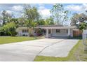 Charming single-story home with lush landscaping, a carport, and a spacious driveway at 140 E Faith Ter, Maitland, FL 32751