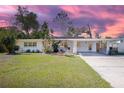 Charming single-story home with lush landscaping, a carport, and a spacious driveway at 140 E Faith Ter, Maitland, FL 32751